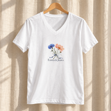 Illustrative hanger scene of one white personalized V-neck tee. Emma & James are examples; printed flowers are fixed; props not included.