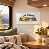 Illustrative RV interior wall decor scene of one 12 x 6 inch decorative aluminum plate. CAMP BENNETT and WEEKEND CREW are personalized examples; mounting hardware and props not included. Not a vehicle registration plate.