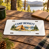 Illustrative camp table scene of one 12 x 6 inch decorative aluminum plate. CAMP BENNETT and WEEKEND CREW are personalized examples; mounting hardware and props not included. Not a vehicle registration plate.