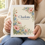 Illustrative size-in-hand view of the matte hardcover journal with example name Charlotte.